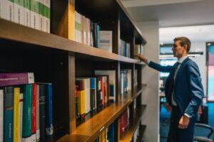 Advocaat van Talo advocaten voor een boekenrek